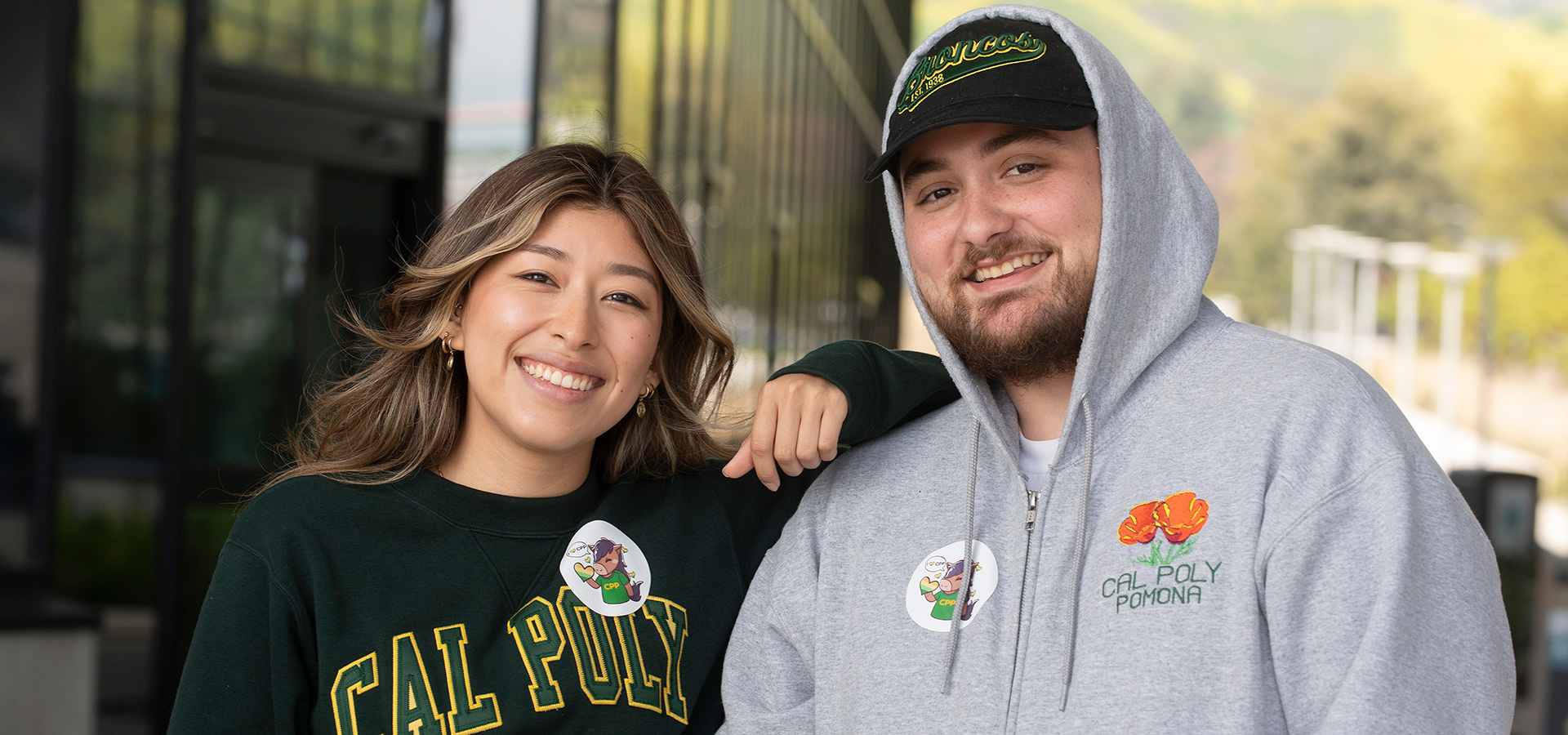 Two students smile while wearing giving day stickers