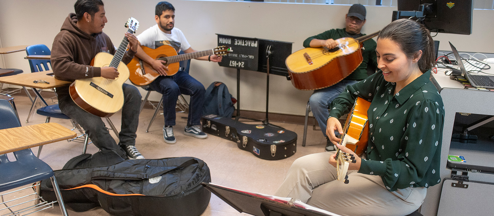 Jesse Vallejo plays guitar with students in her Musics of Mexico class.