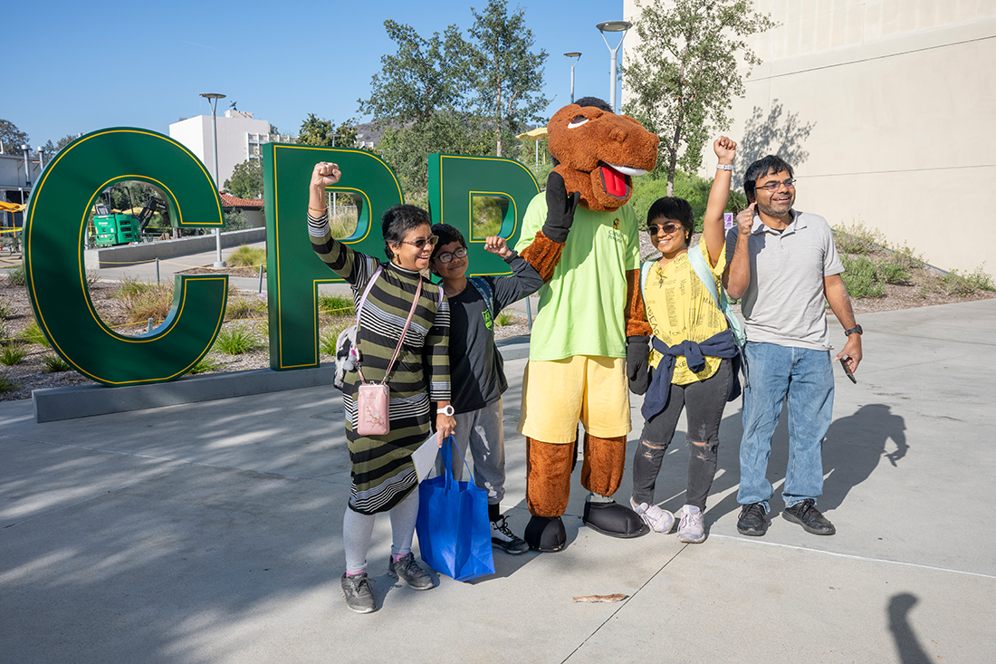 A family celebrates and pose for a photo in front of the CPP Letters. 