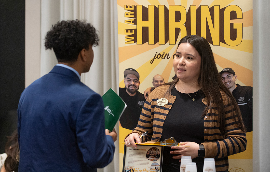 A male black student speaks with a respresentative from Portos during a Career Fair.