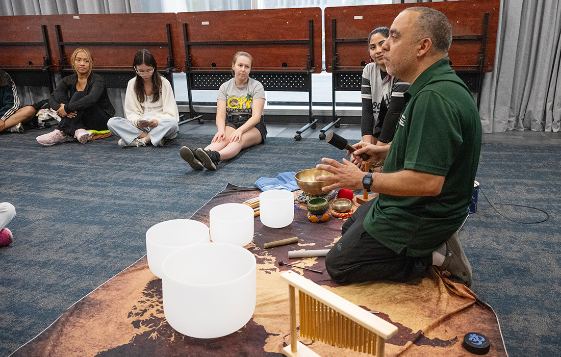 Paul Knopf in a sound bath session while students listen intently at the Pomona Public Library