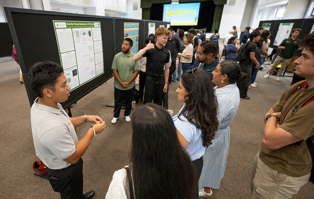 Students gather around a research poster caleld Heat-Sink Thermal Simulation in ANSYS