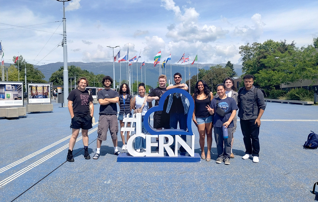 A group of College of Science student pose on site in front of CERN letters. 
