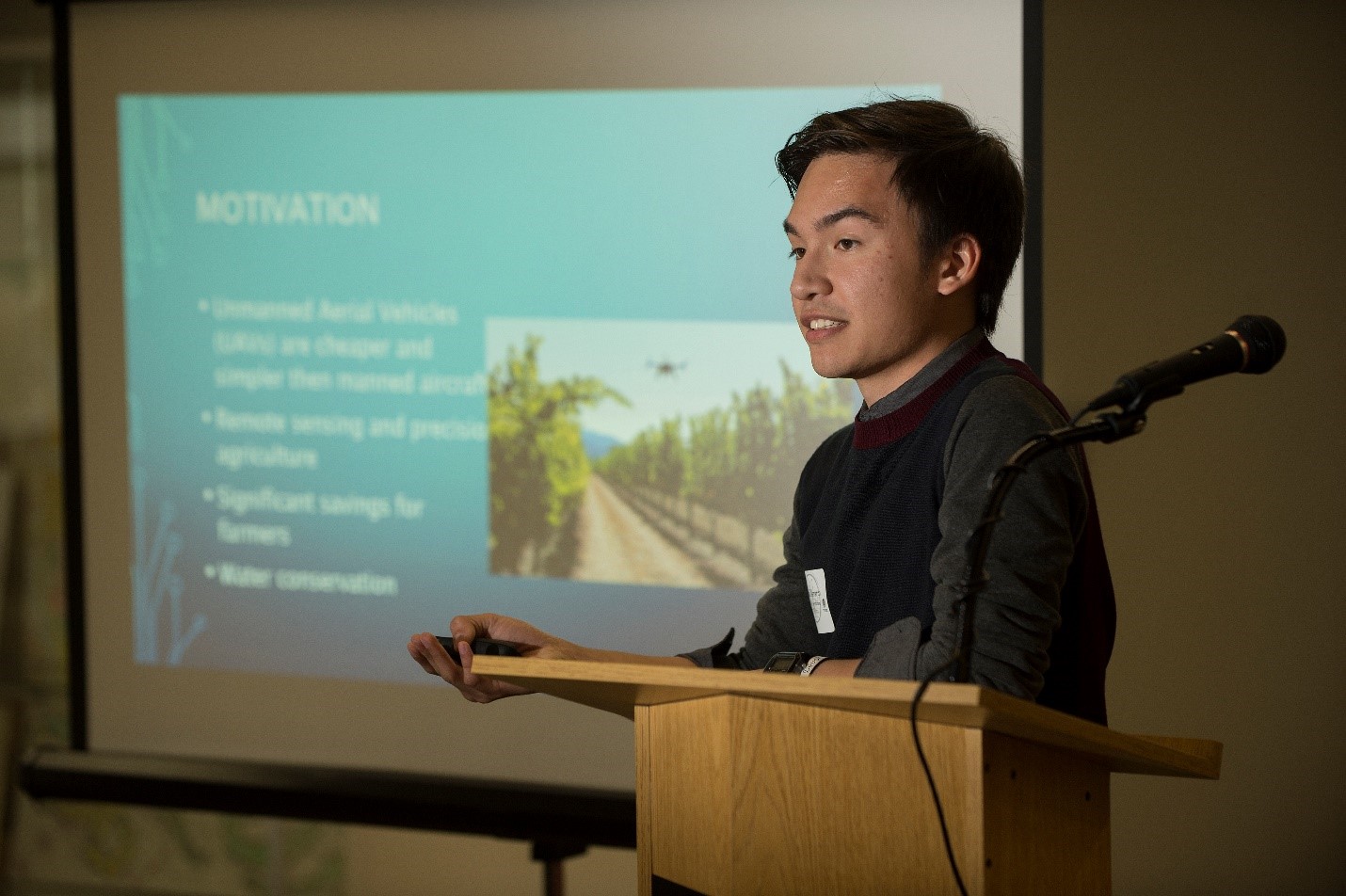 student presenting on podium at research event