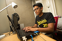 A Cal Poly Pomona student typing on his computer