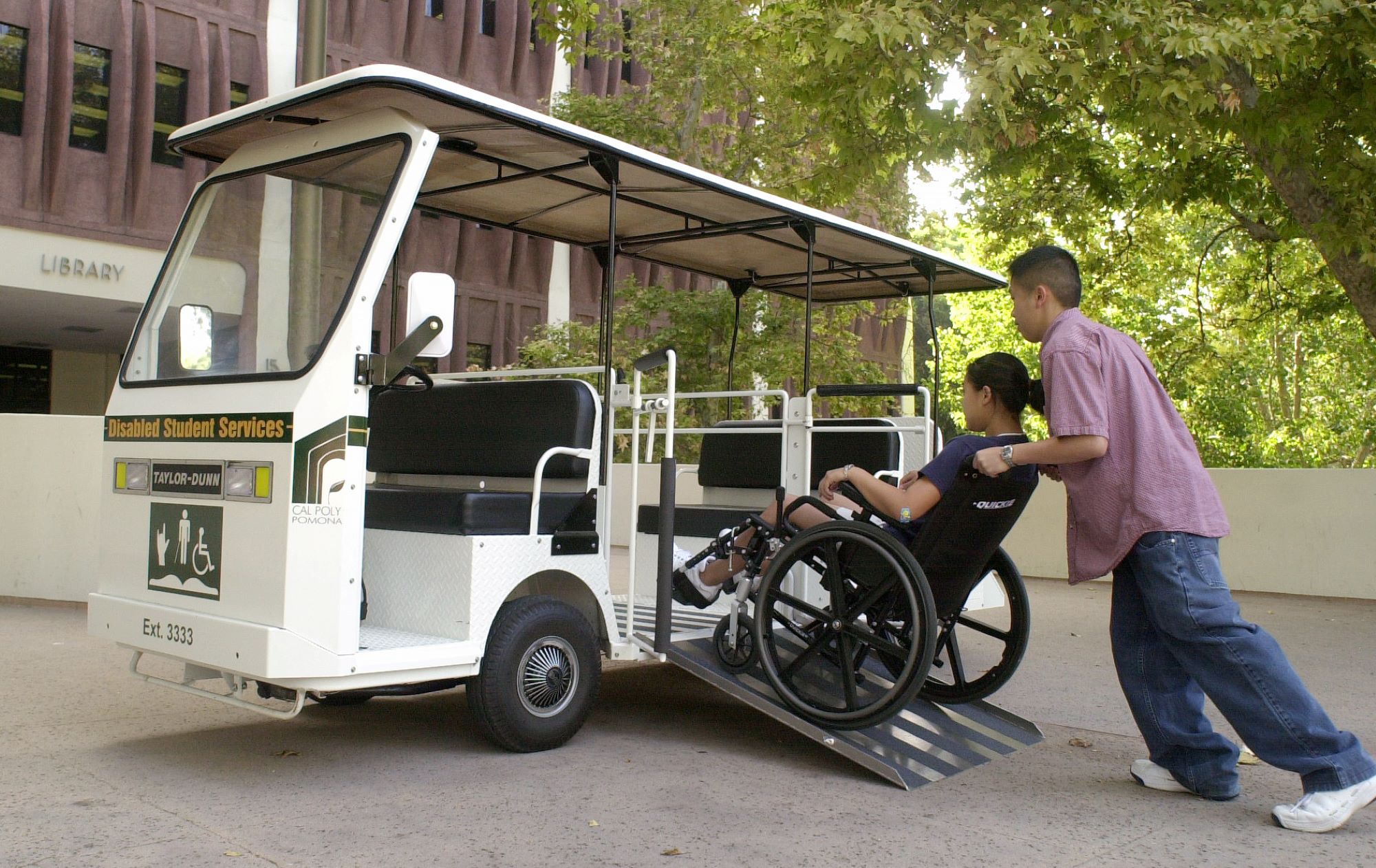 A female student being assisted onto an ADA cart
