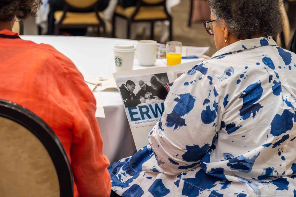 A teacher holds an ERWC info packet