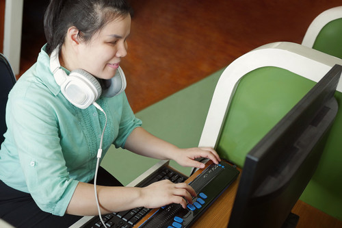 A blind student using a computer through a braille display. 