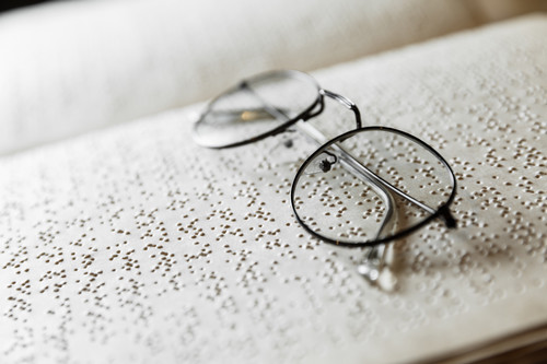 glasses sitting on braille text