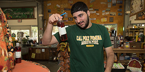 A student checks the label on a bottle at the Cal Poly Pomona farm store. 