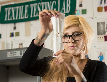A female student tests the strength of textiles