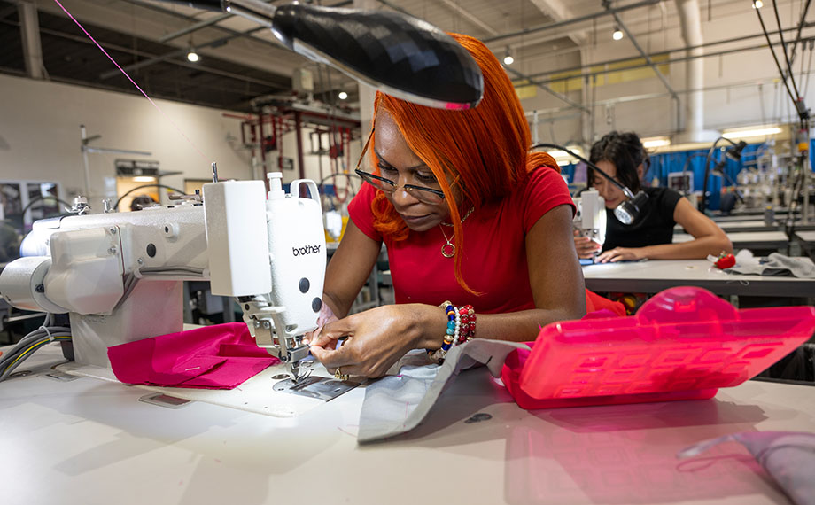 A female student uses a sewing machine in the Production Lab