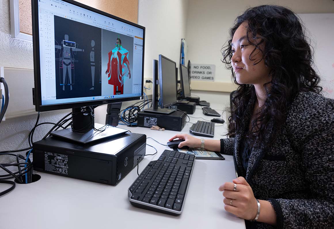 A female student designs a garment on a computer