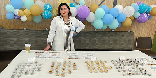A female DI student at a table with food samples.
