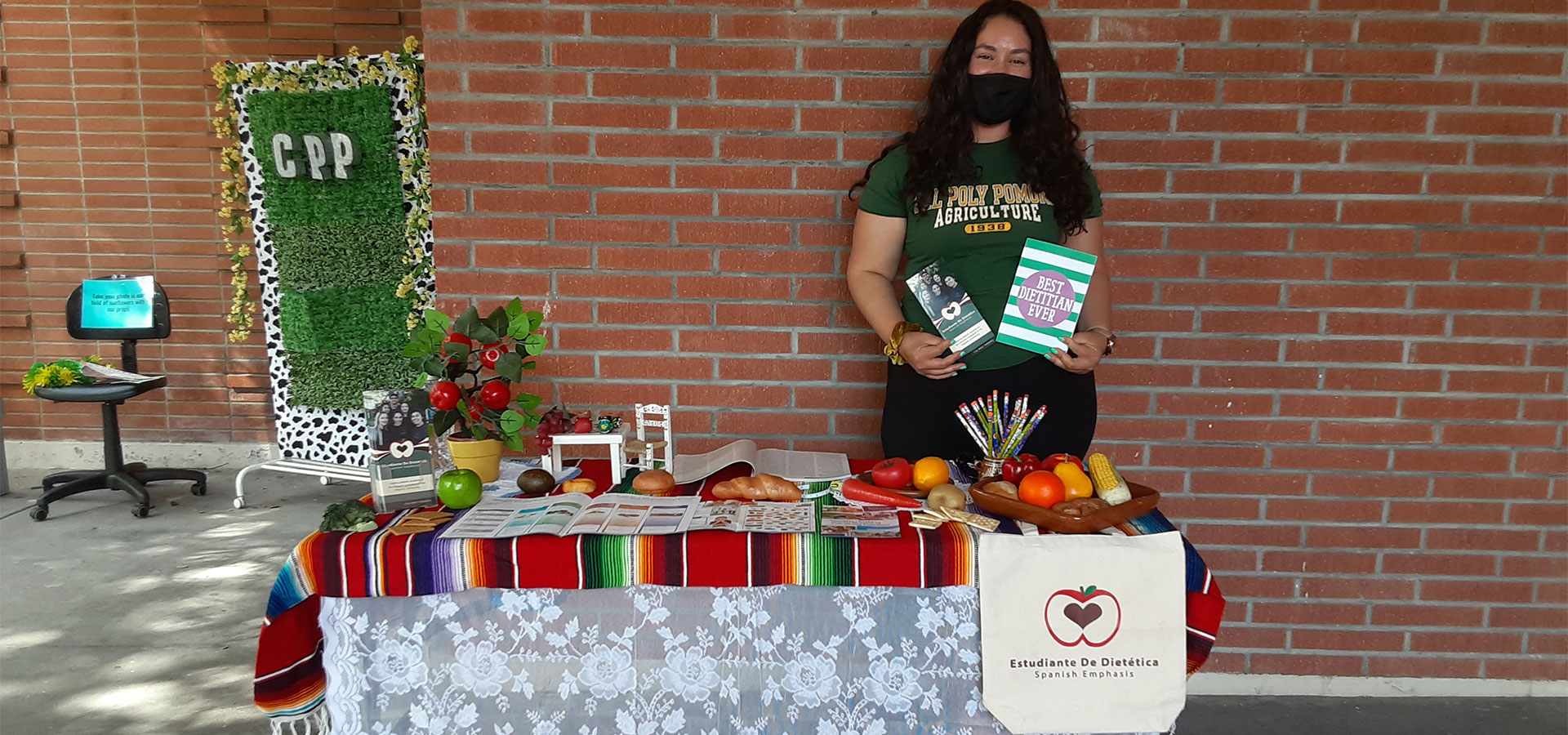 A female student staffing an ED table outside a building