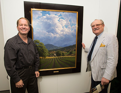 Don Huntley poses with an artist and his painting