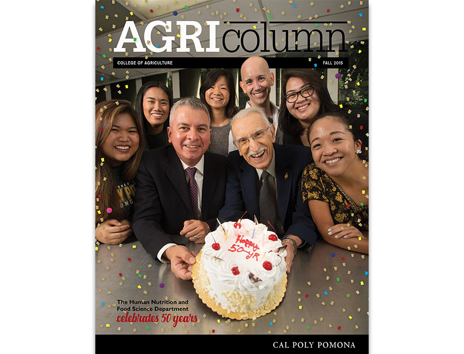 Students and two faculty pose with a cake.