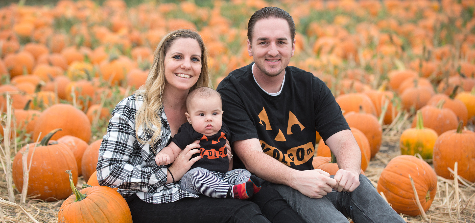 A couple with their infant at the 2018 alumni preview night at the Pumpkin Festival
