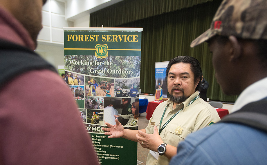 A U.S. Forest Service rep speaks to students at a career fair.