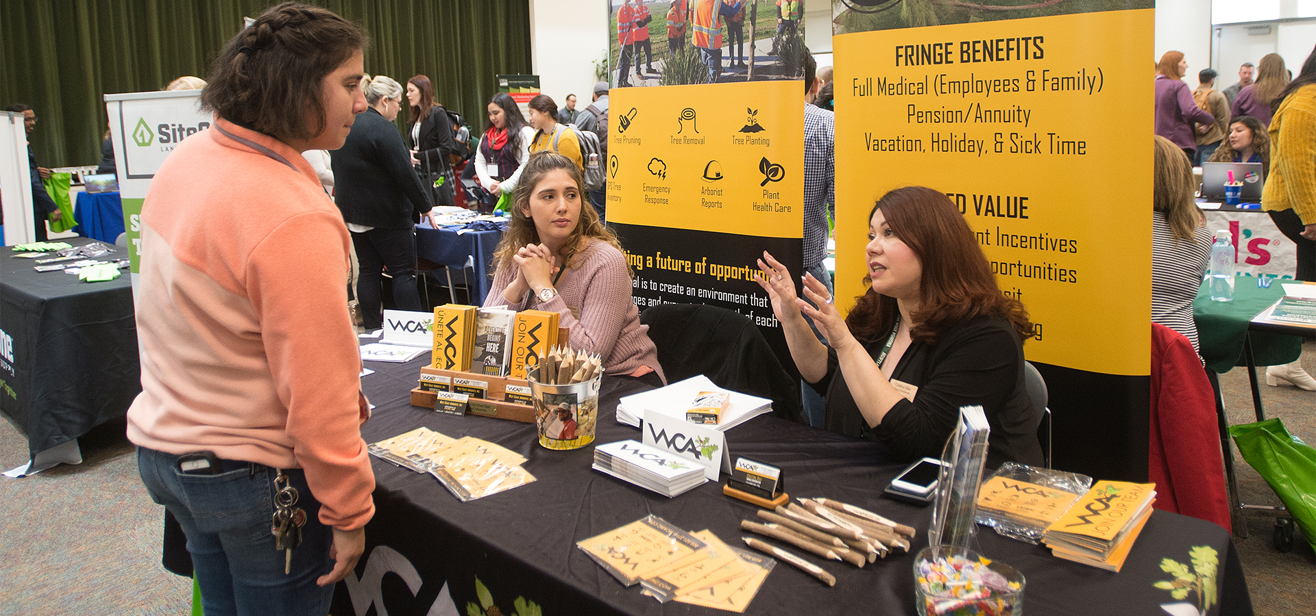 A student speaks to representatives at the West Coast Arborists booth at the 2019 Ag Career Day