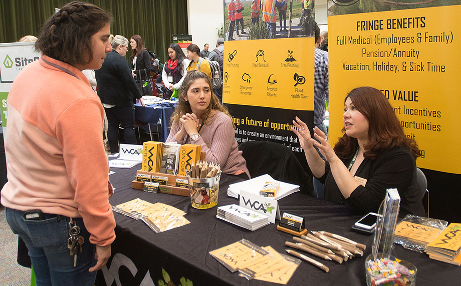 A female student talks to recruiters from West Coast Arborists.
