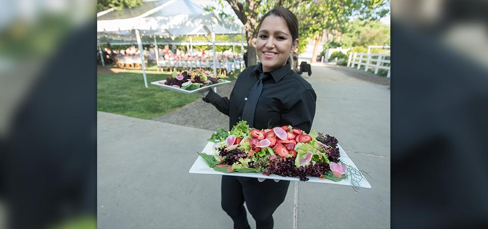 A server shows off the salad