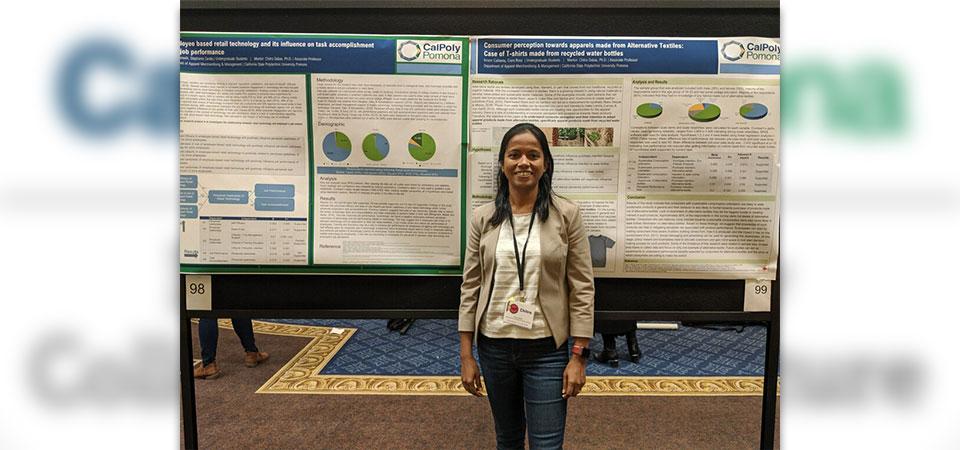 Associate Professor Chitra Dabas standing in front of a poster presentation
