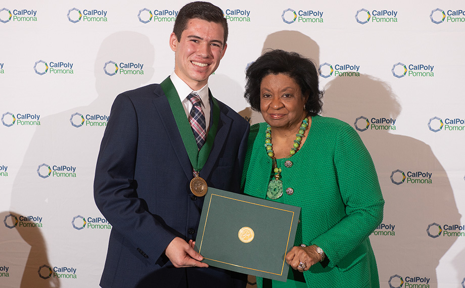 A student receives a scholarship from President Coley