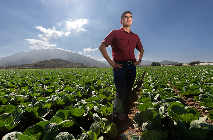 Plant science alumnus Cornelio Blanco stands in a field of a farm he manages.