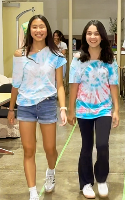 Two girls model tie-dyed t-shirts.