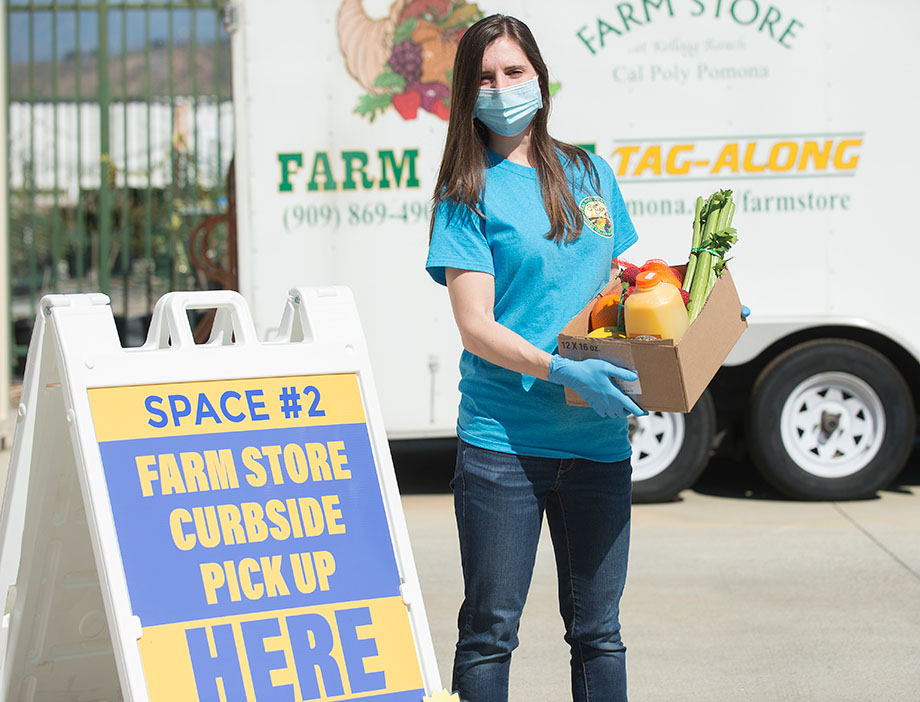 A Farm Store employee with a box of groceries 
