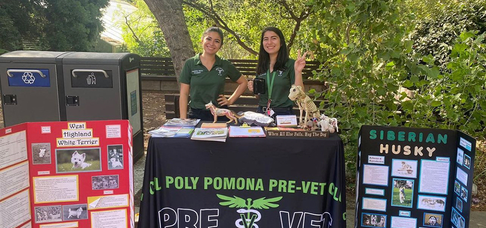 Two female students man the pre-vet table at open house