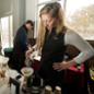 A woman pours hot water through a coffee filter into a pot.