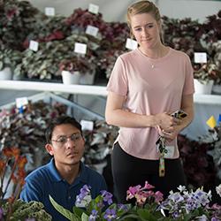 Students Brandon Franco and Emma Riley look over flowers on display at flower show.