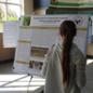 visitor examines poster board of research