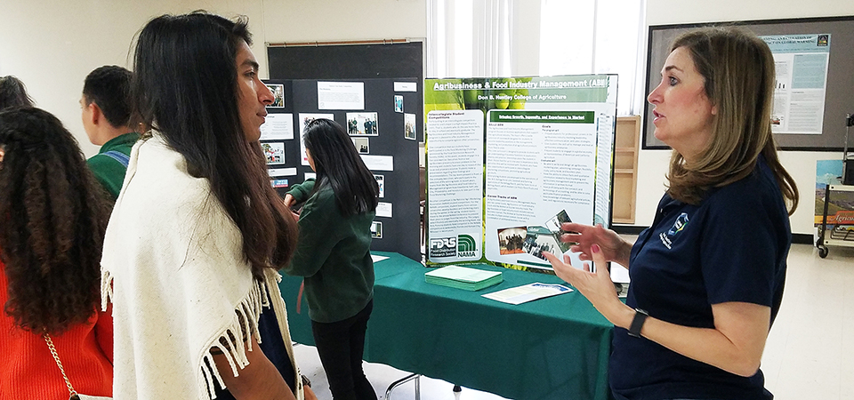 A female faculty member speaks with a prospective student