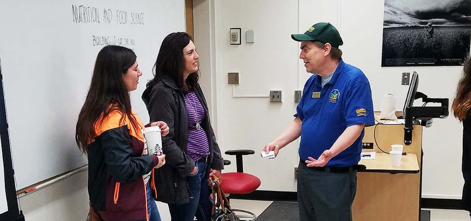 Professor Jon Phillips speaks with two women