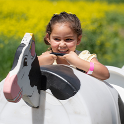 A child smiles as she rides in one of the Cow Train cars