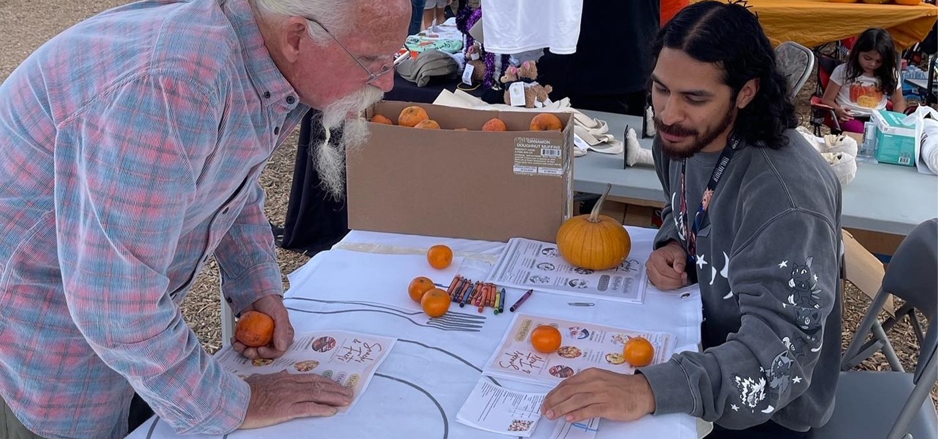 A nutrition student speaks with an elderly man at the booth