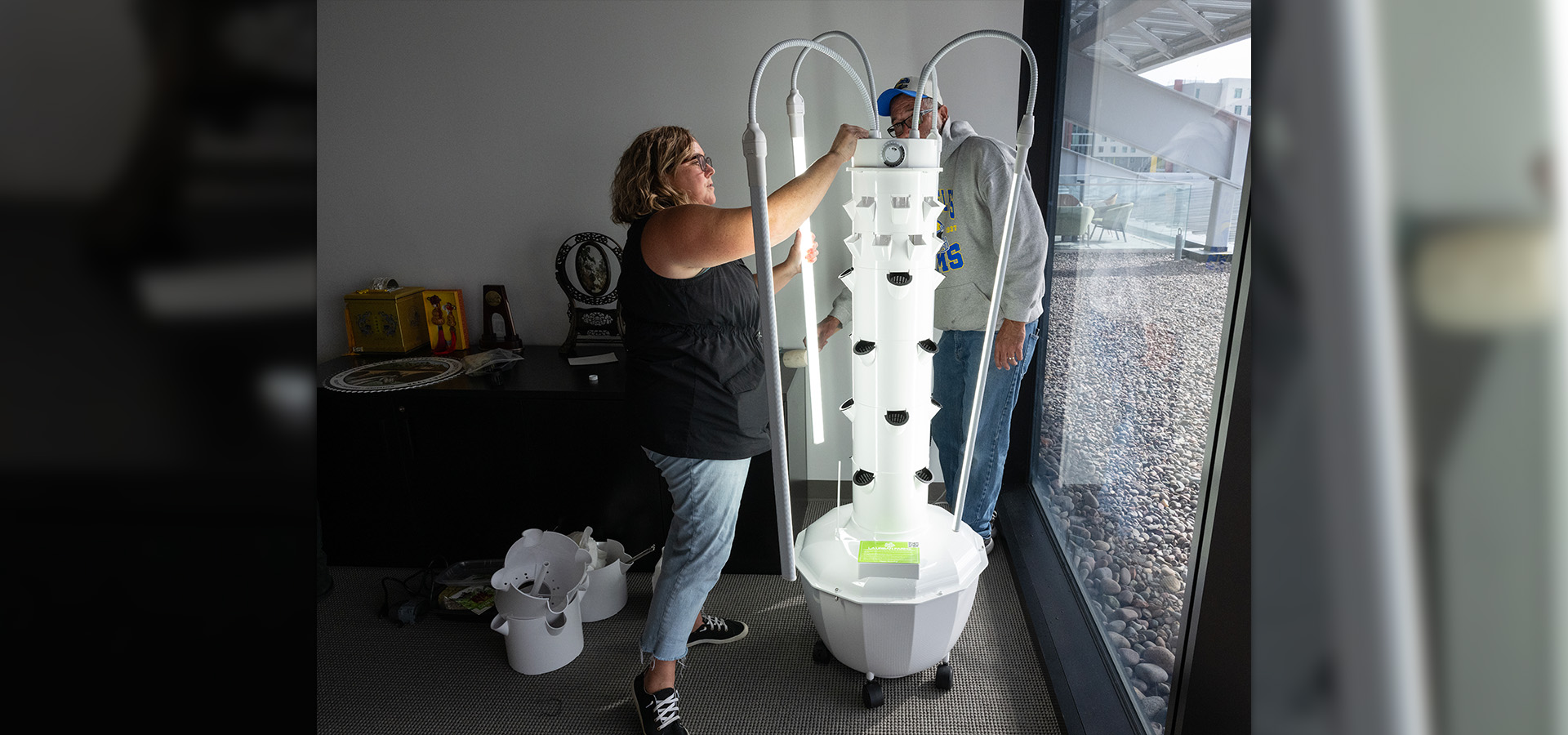 A man and a woman install a vertical garden.