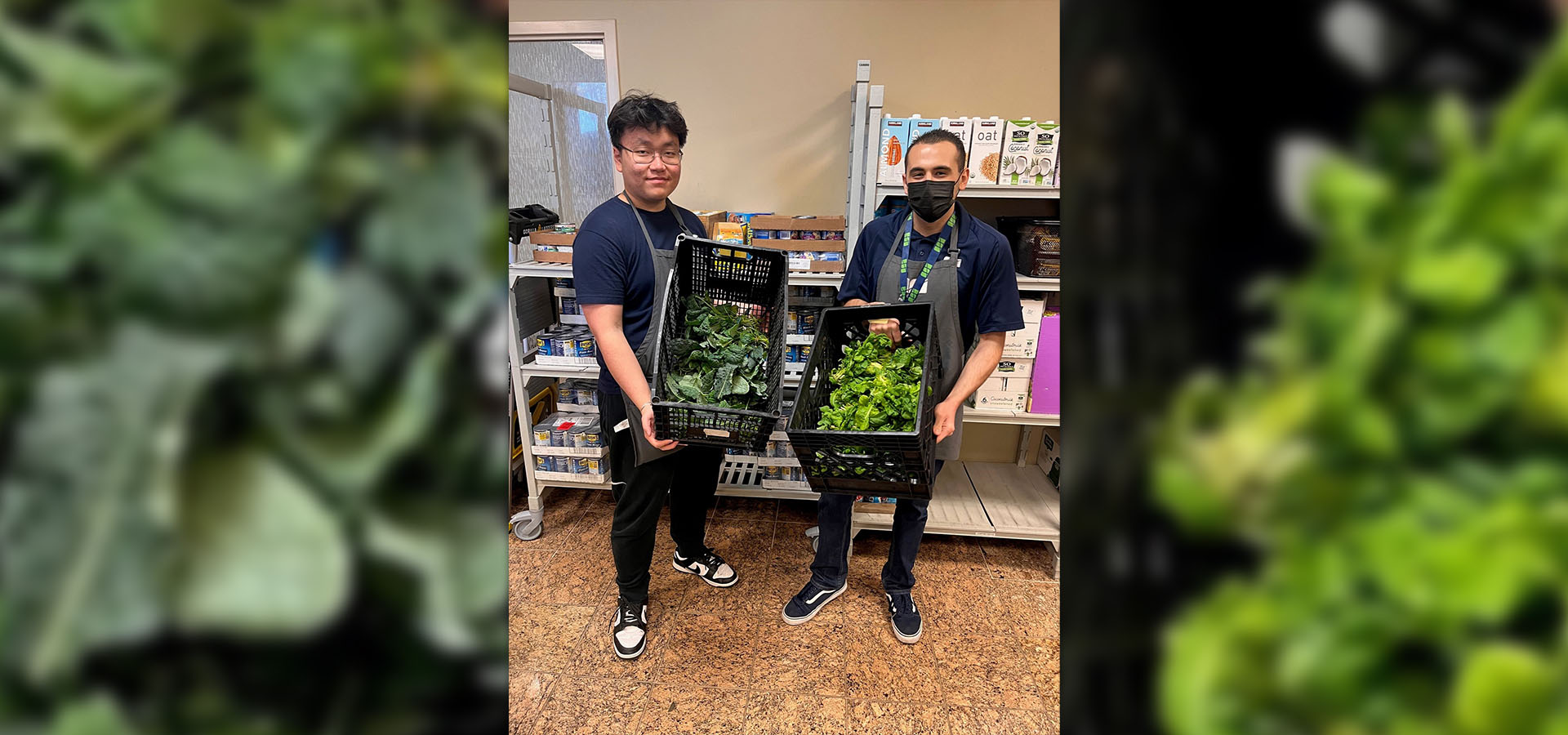 Two students hold up crates of produce