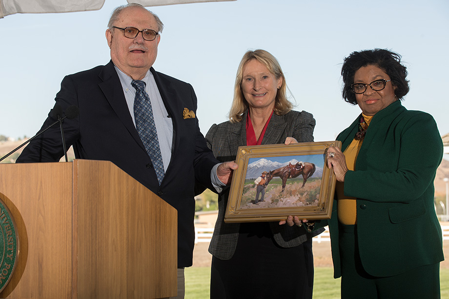 Don B. Huntley at a podium with Dean Mary-Holz-Clause and President Soraya Coley. 