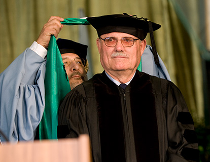 Don B. Huntley in cap and gown receiving his honorary doctorate.