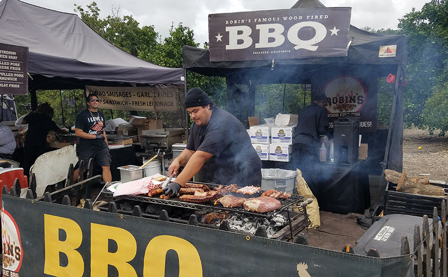 A vendor grills meat.