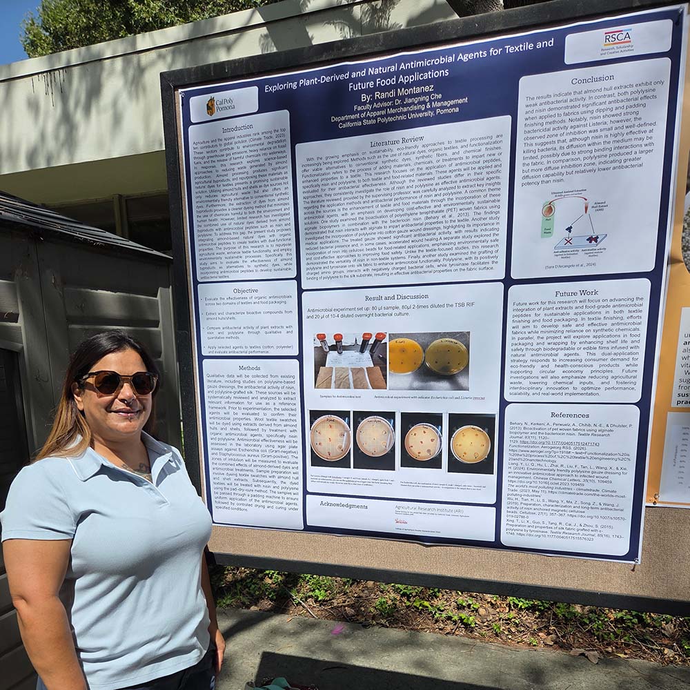 A woman stands in front of a poster presentation on plant-derived and natural antimicrobial agents for textile and food applications.