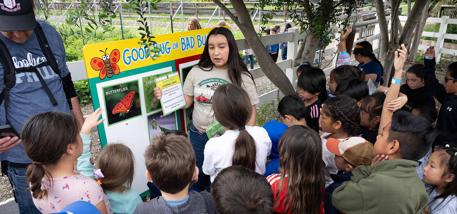 Children listen to a student present about insects.