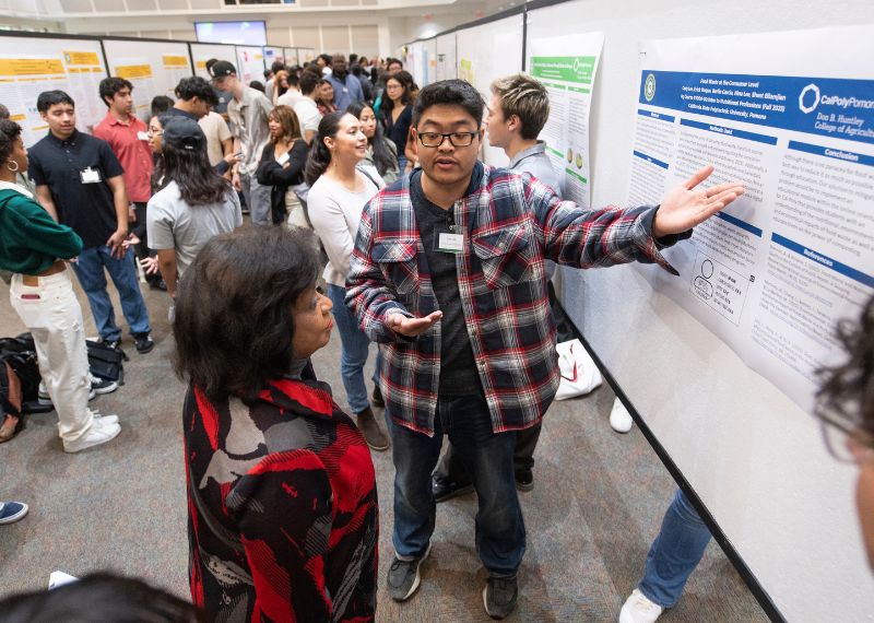 CPP student presents research poster to President Coley.