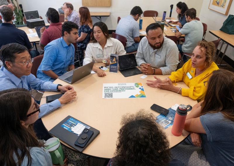 Office of Academic Innovation team seated at a table. 