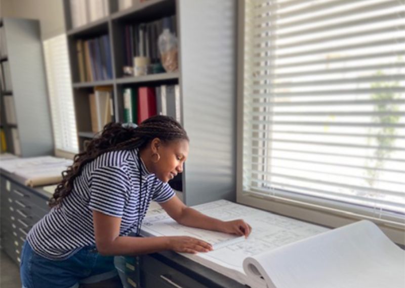 Student reading pages of blueprints.