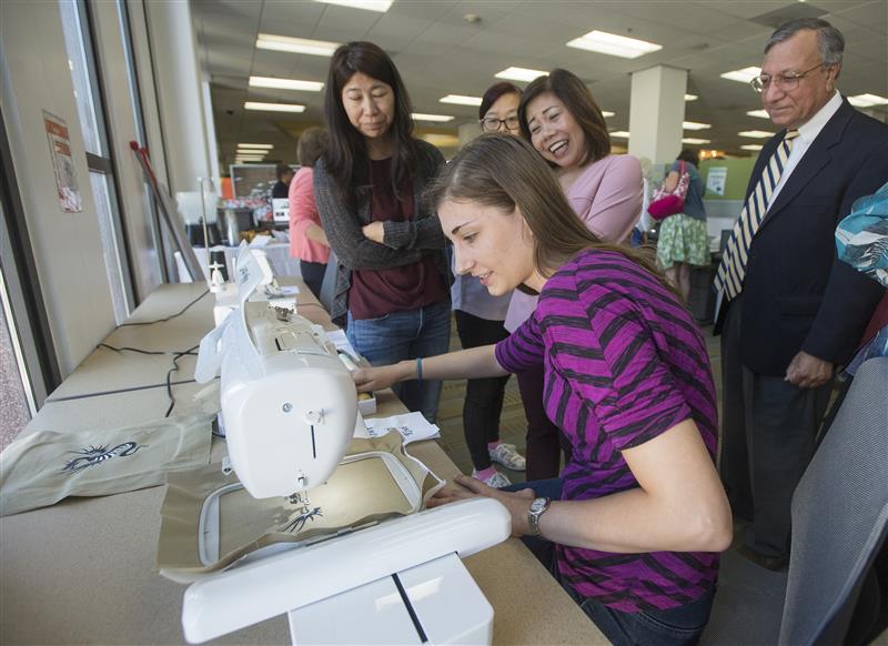 SIIL Ambassador teaches trainees how to operate the sewing machine.
